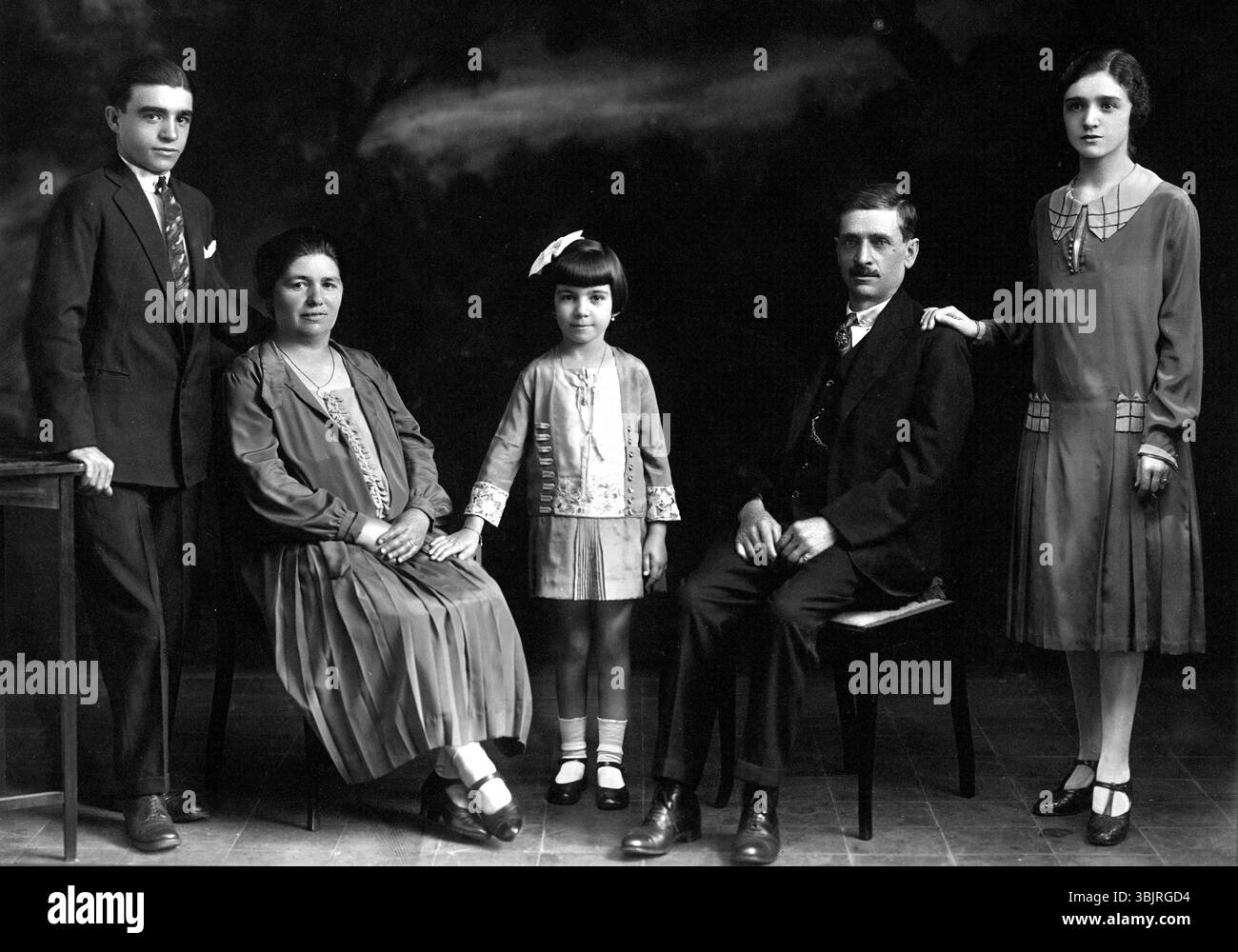 Family with children, 1930s, A family poses formally in a photo studio ...