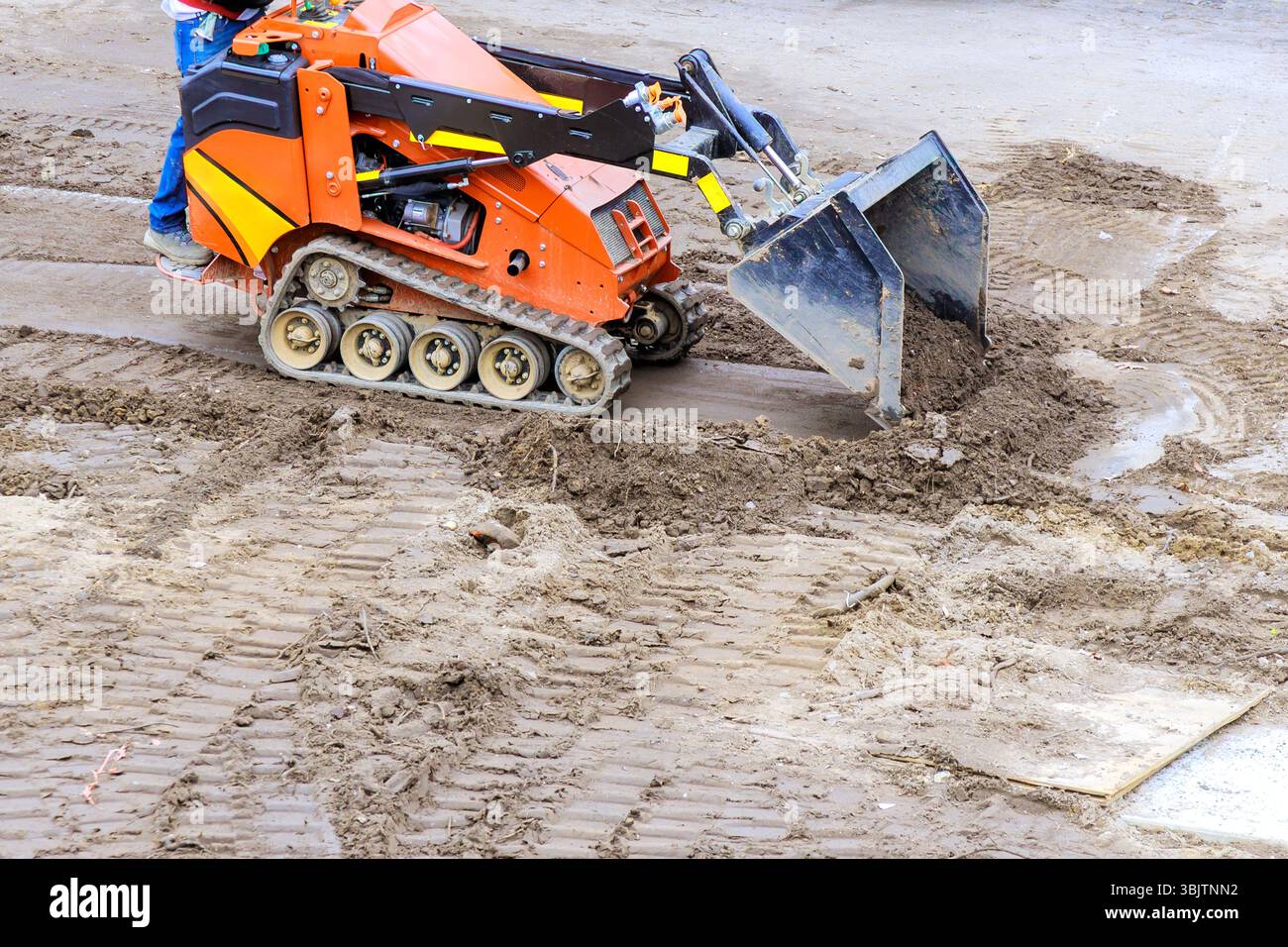 Compact track loader is used to move level soil at construction site ...