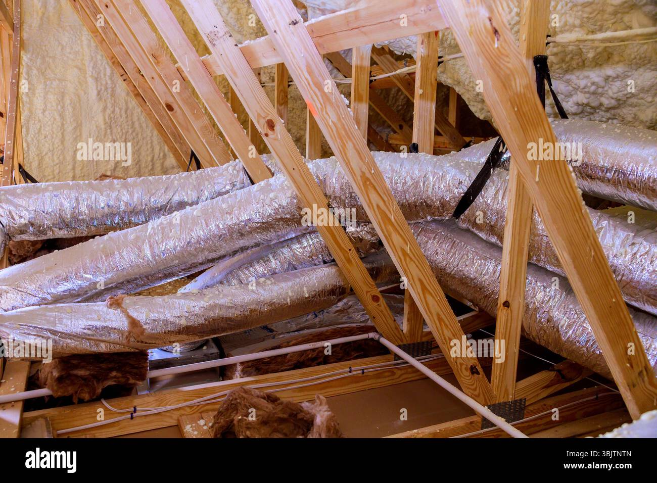 Picture of Exposed ductwork wooden beams in renovated attic showcase insulation ...