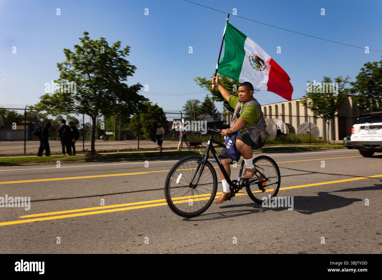 A protester rides a bike while waving a Mexican flag during a march ...