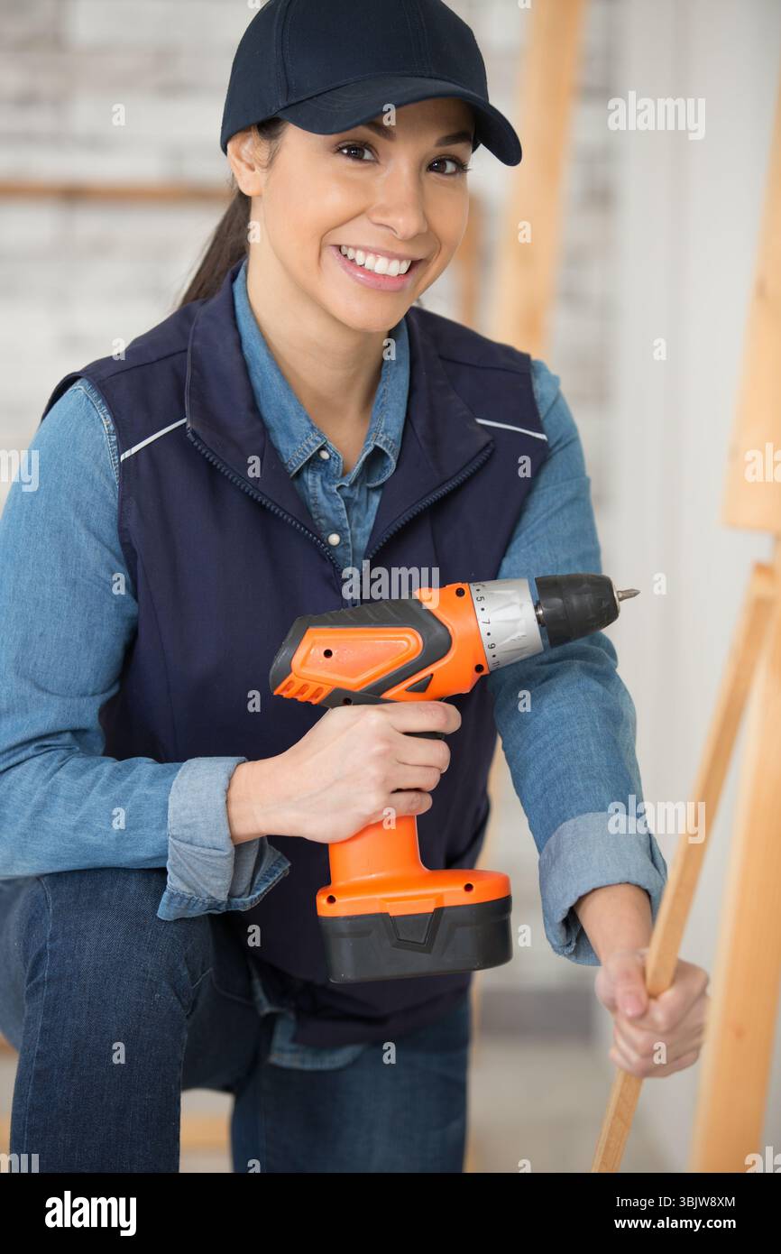 female builder using an electric screwdriver Stock Photo