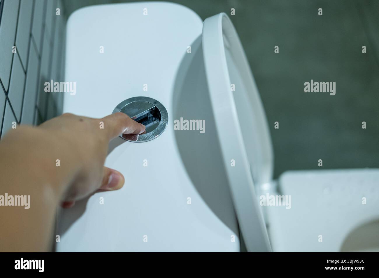 Hand pressing the flush button Stock Photo - Alamy
