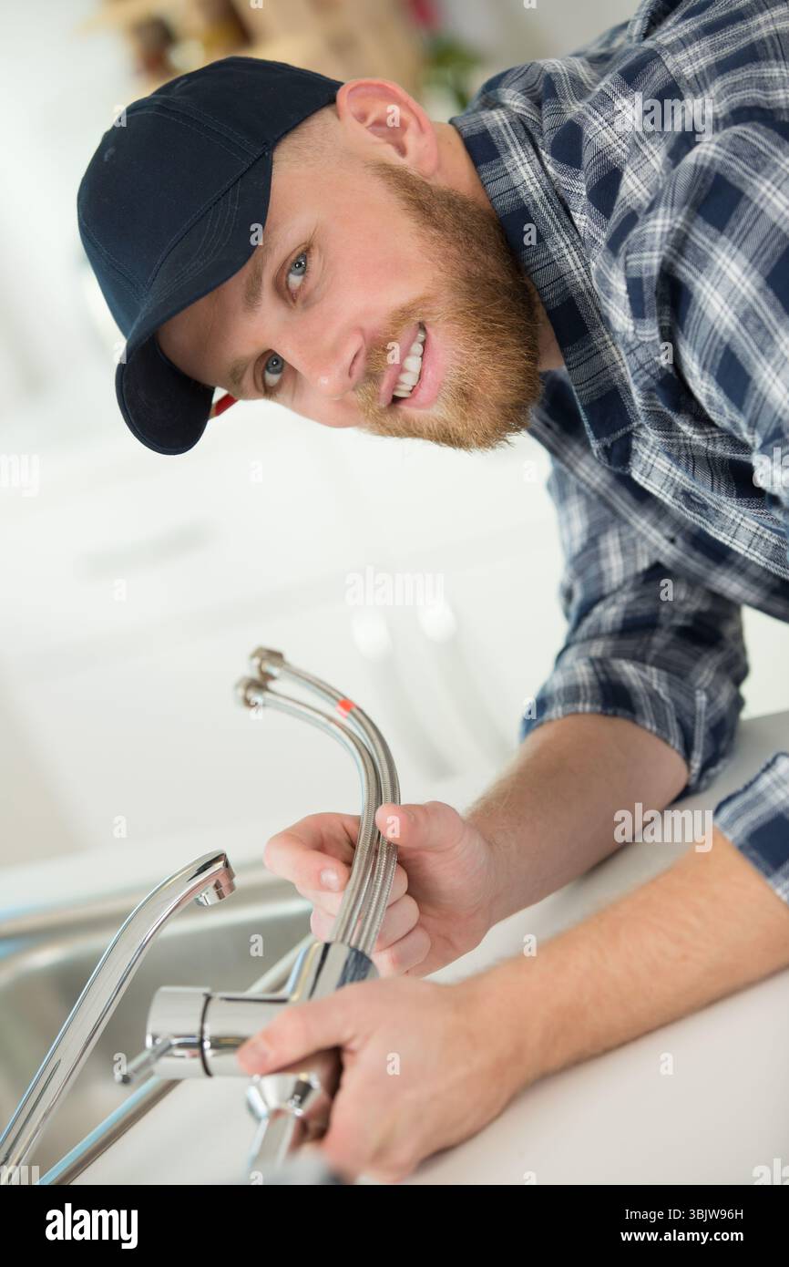 young professional plumber assembling sink pipe Stock Photo