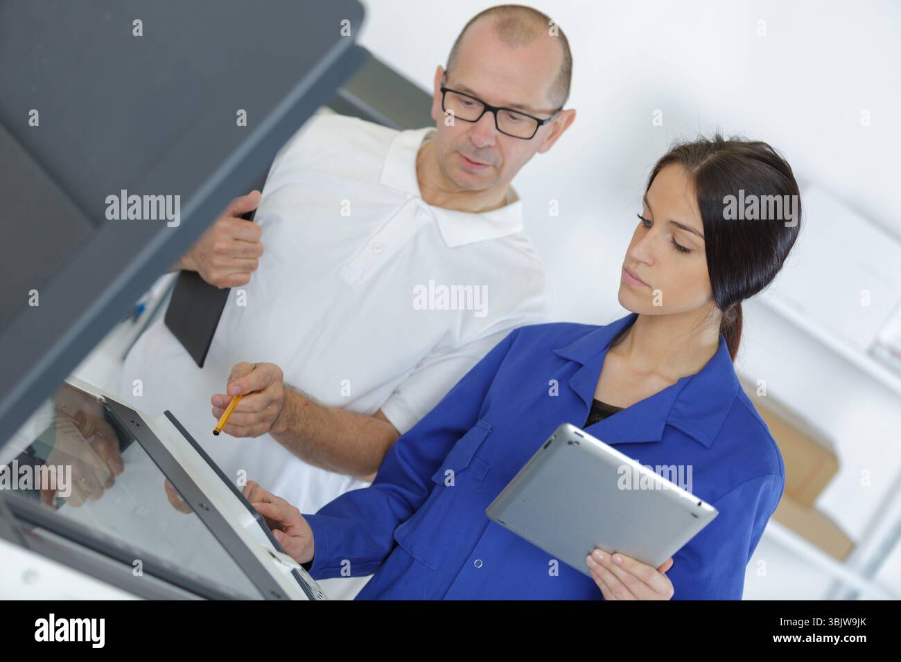 a woman fixing printer machine Stock Photo