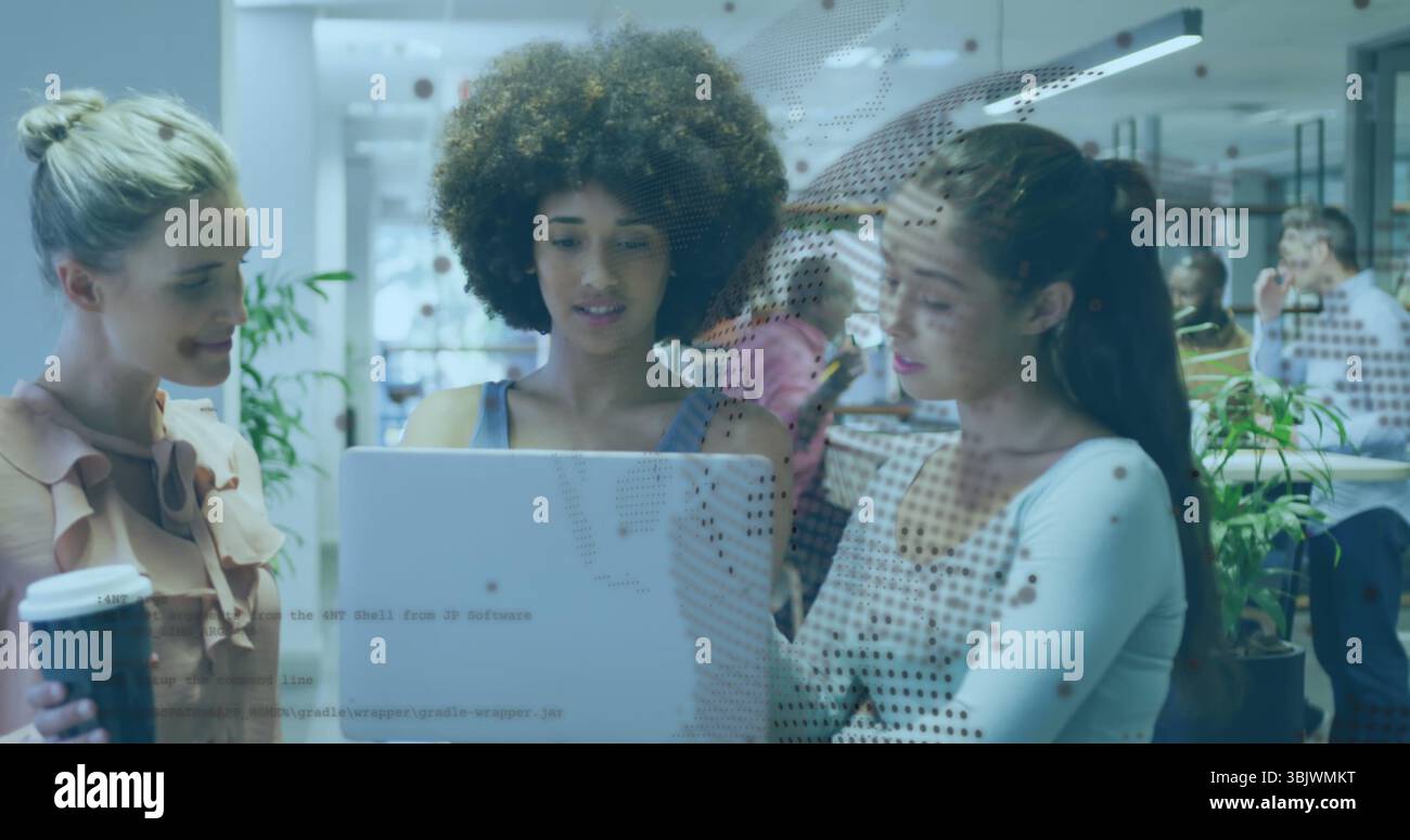 Discussing work three colleagues leaning over laptop at open-plan office, with takeaway coffee cup Stock Photo