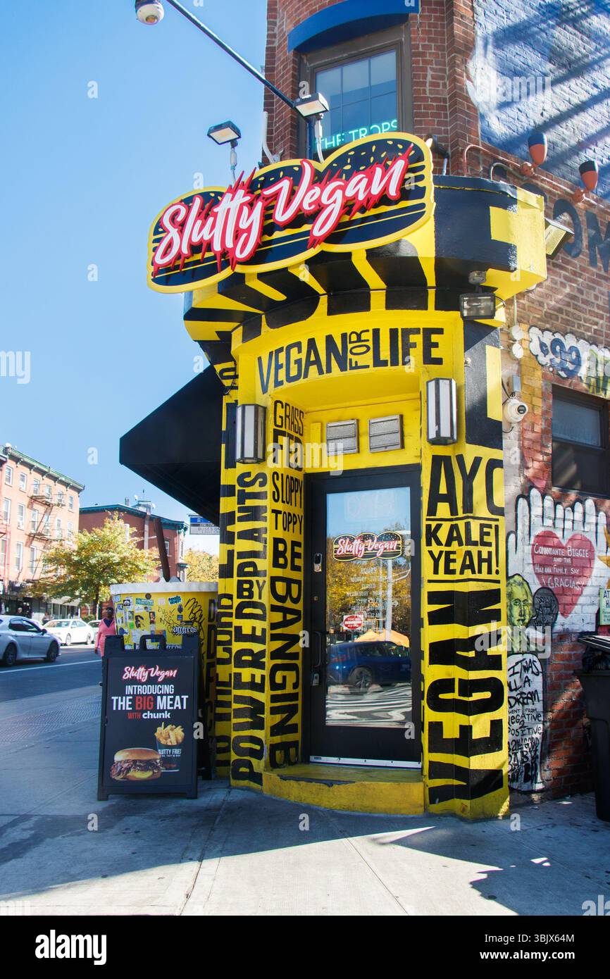 Street view of a vibrant vegan restaurant slutty vegan with a bold neon sign and colorful design on a sunny day in an urban setting Brooklyn nyc Stock Photo