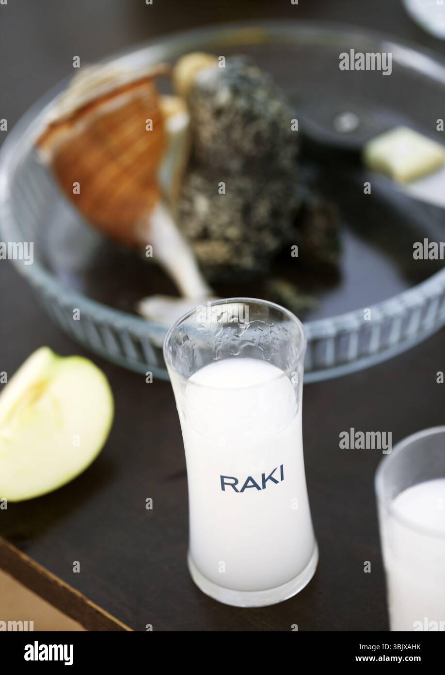 Full glass of Turkish vodka raki, apple and seafood at background Stock Photo