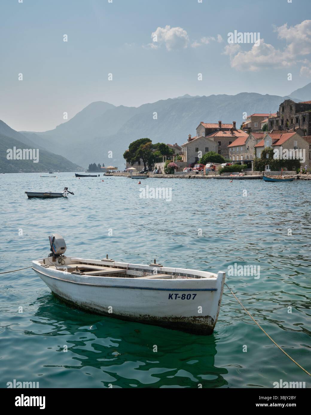 perast-montenegro-june-12-2025-white-motorboat-moored-on-turquoise