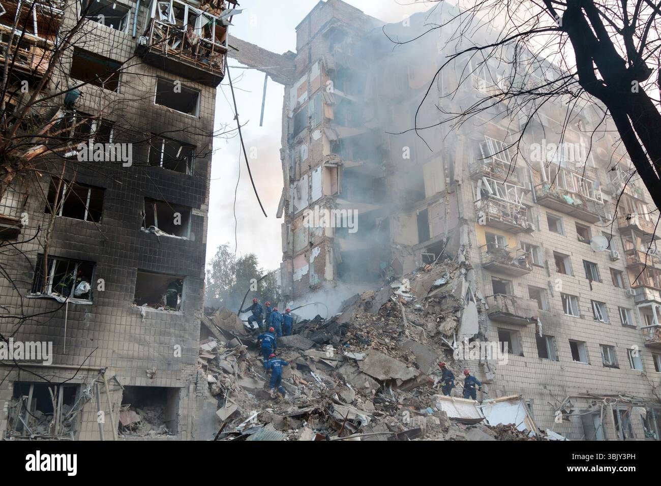 Rescuers clear debris at an apartment block in the Solomianskyi ...