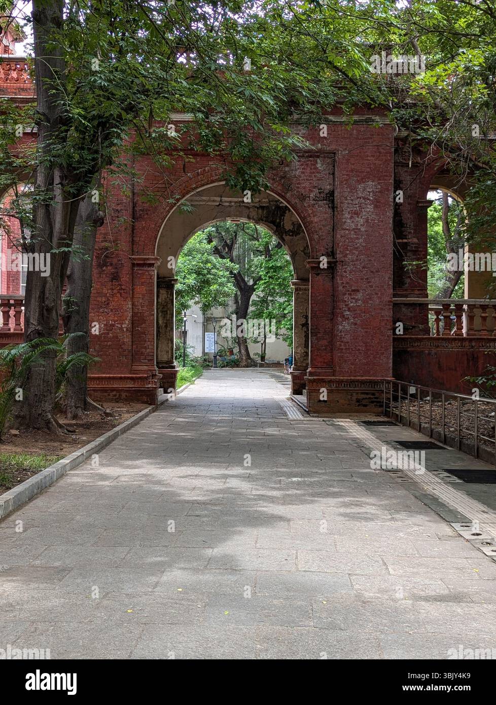 A walk through time. Weathered bricks, graceful arches, and dappled light — a quiet passage where the past lingers gently. - Smartphone Captured Stock Image