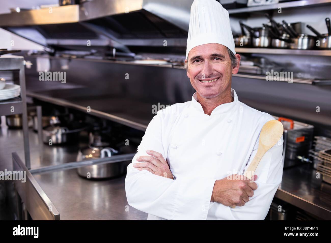 Commercial stove burners heating saucepots, frying pans on stainless steel cooking line in kitchen Stock Photo