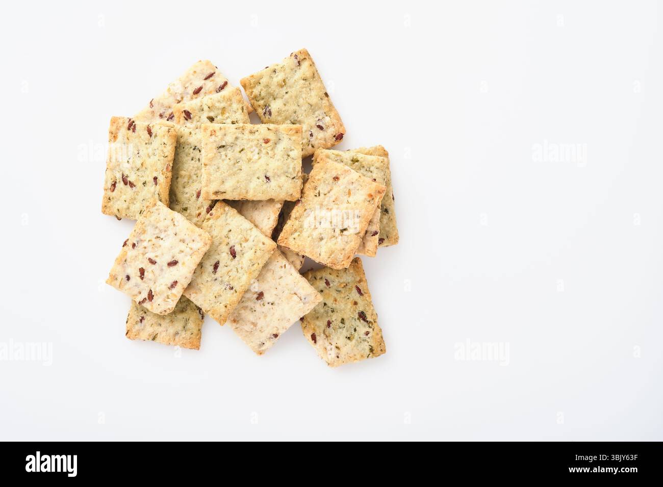 Stack of grain salty crackers with bran and flax seeds on white background. Top view. Stock Photo