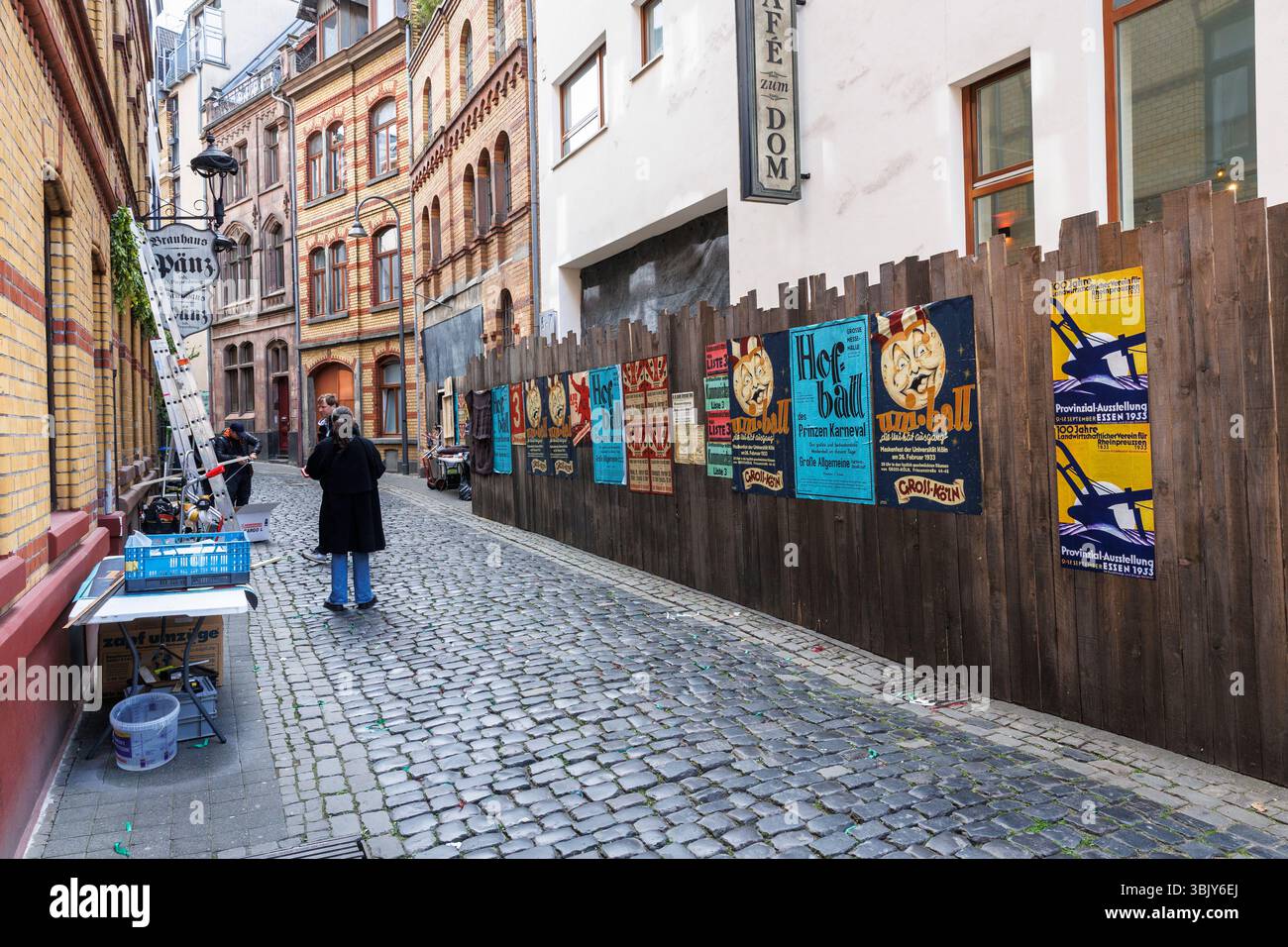 film set in the street Stavenhof in the Eigelstein quarter, carnival posters and political posters from the 1930s on a wooden fence, Cologne, Germany. Stock Photo