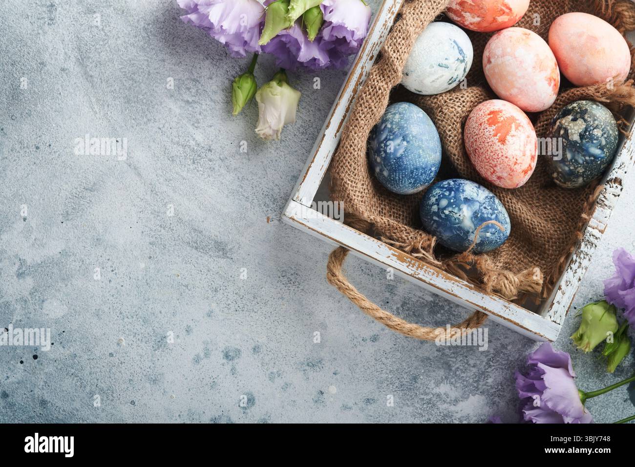 Easter eggs. Dyed Easter eggs with marble stone effect ref and blue color in rustic style on light grey stone background. Easter Stock Photo