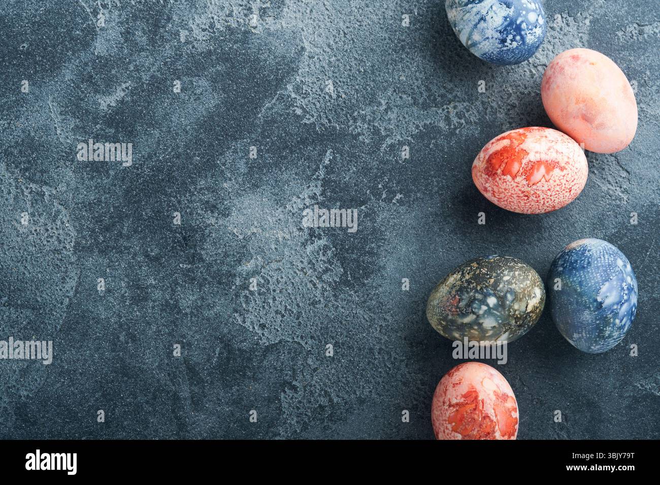 Easter eggs. Dyed Easter eggs with marble stone effect ref and blue color in rustic style on dark stone background. Easter back Stock Photo