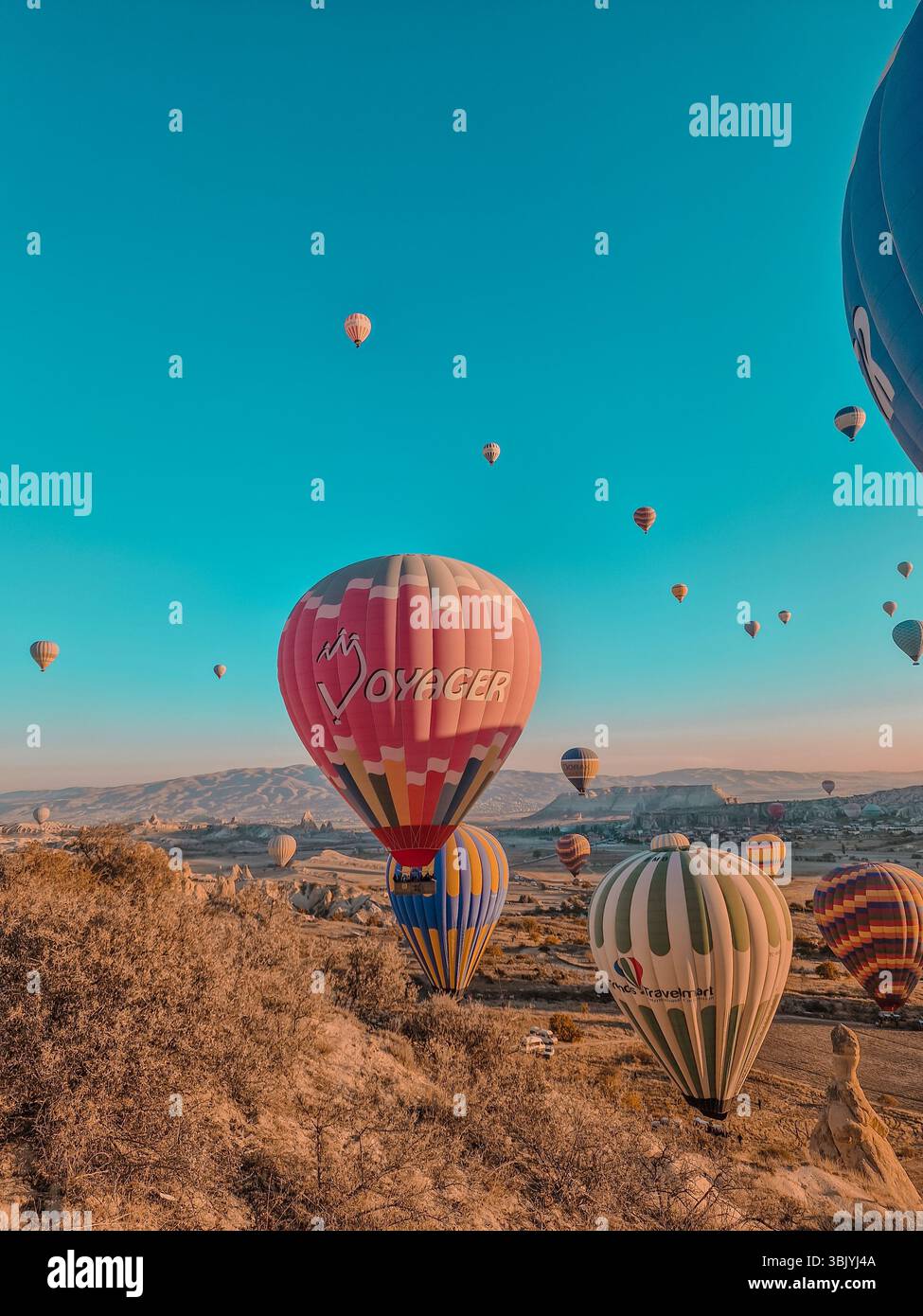 Hot air balloons start landing near love valley, Goreme Turkey. - Smartphone Captured Stock Image