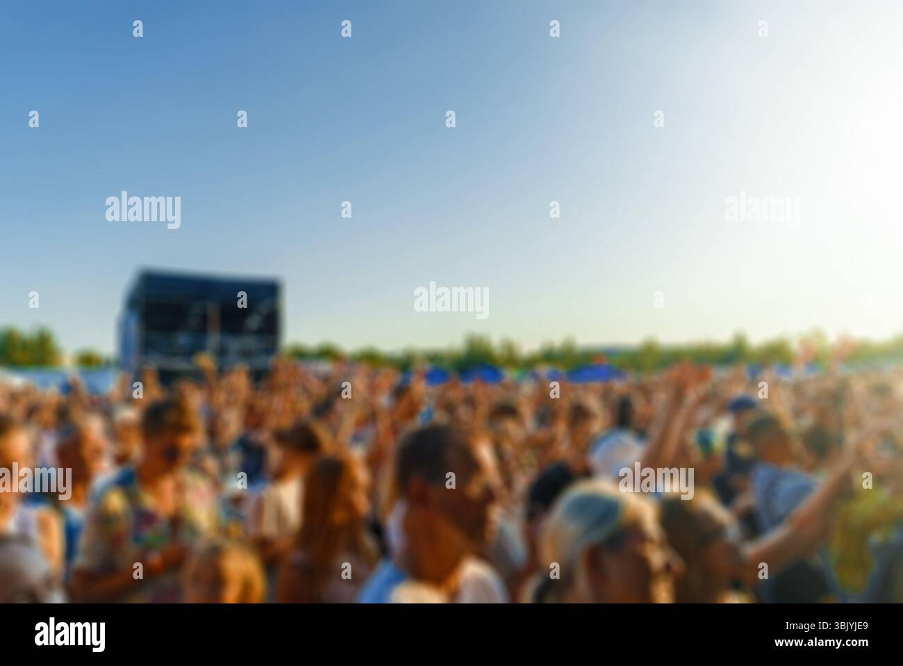 People watching music concert on large stage. Blurred image. Stock Photo