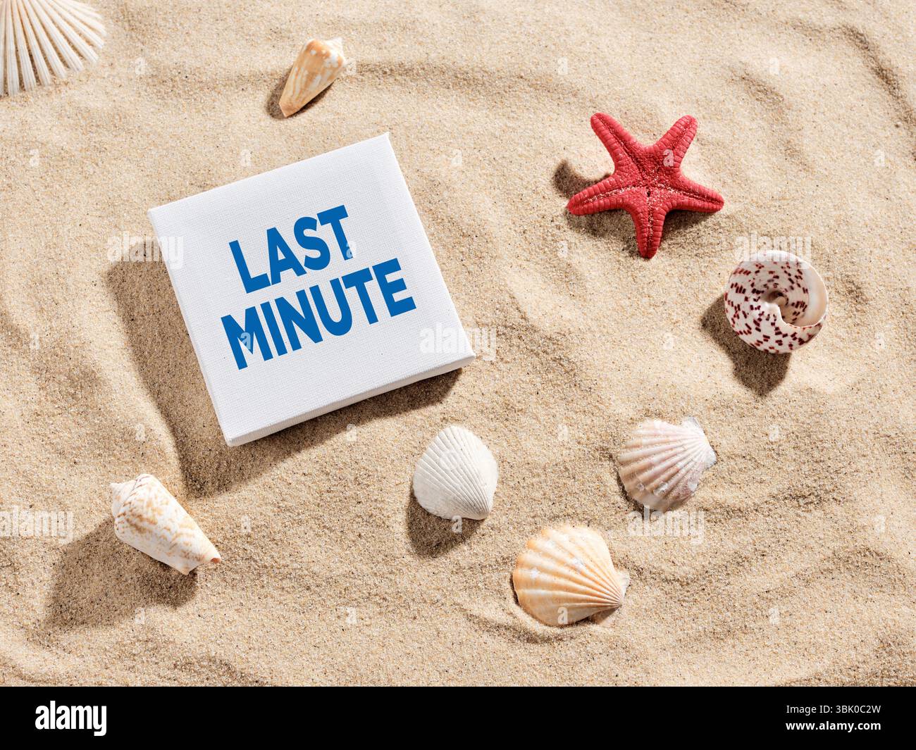 Sign displaying the words last minute surrounded by seashells on a sandy beach evoking a last minute travel deal Stock Photo