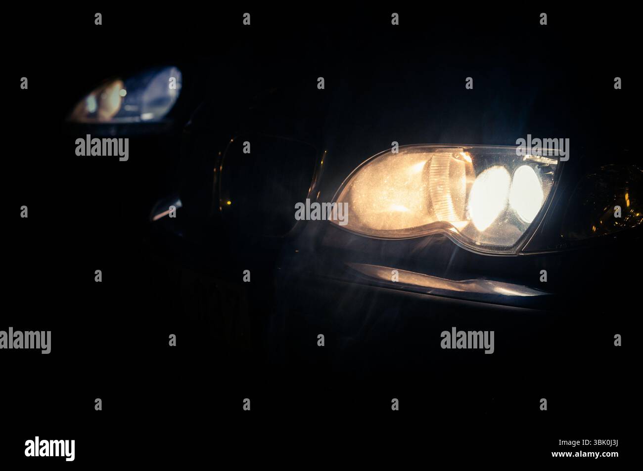 Car Headlights of a car at night Stock Photo