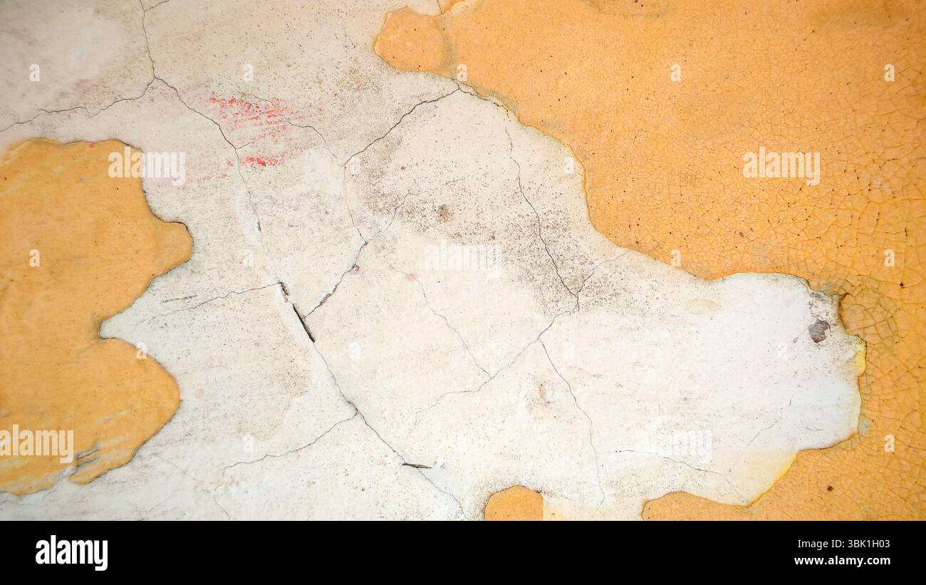 Cracked and Peeling Yellow Wall Texture with Exposed Plaster Stock Photo