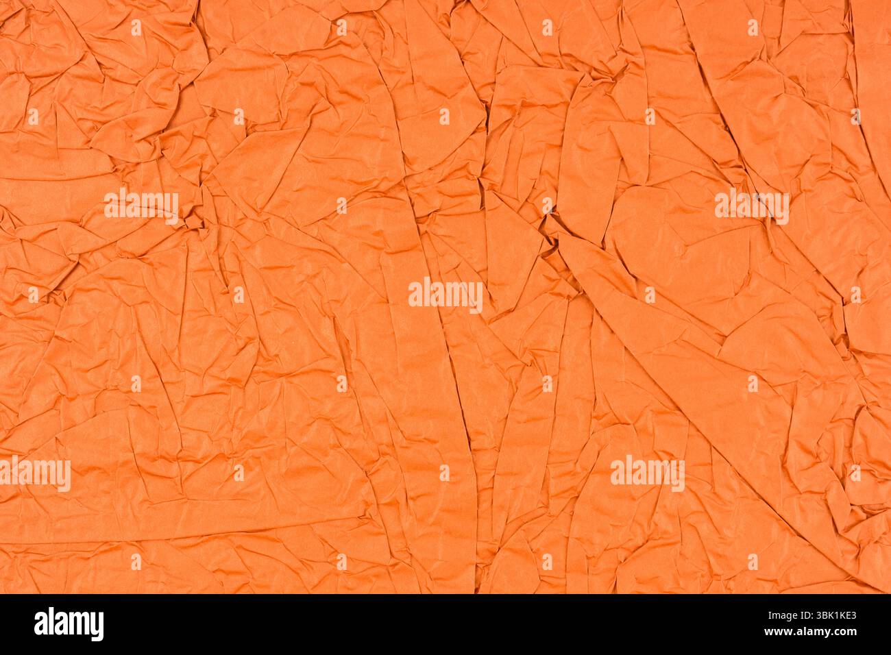 Orange color crumpled paper texture as background. Stock Photo