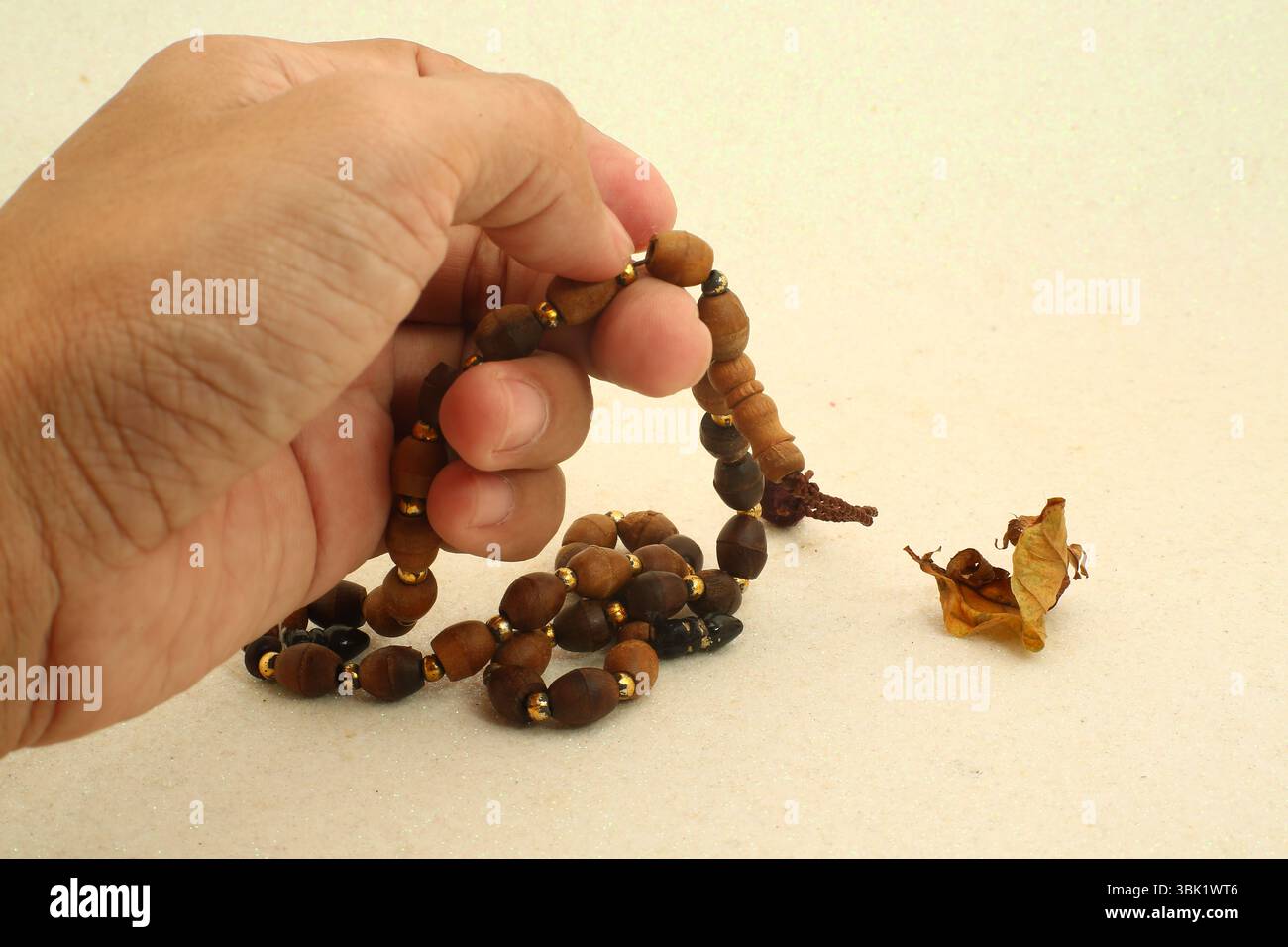 Hands holding prayer beads hi-res stock photography and images - Alamy