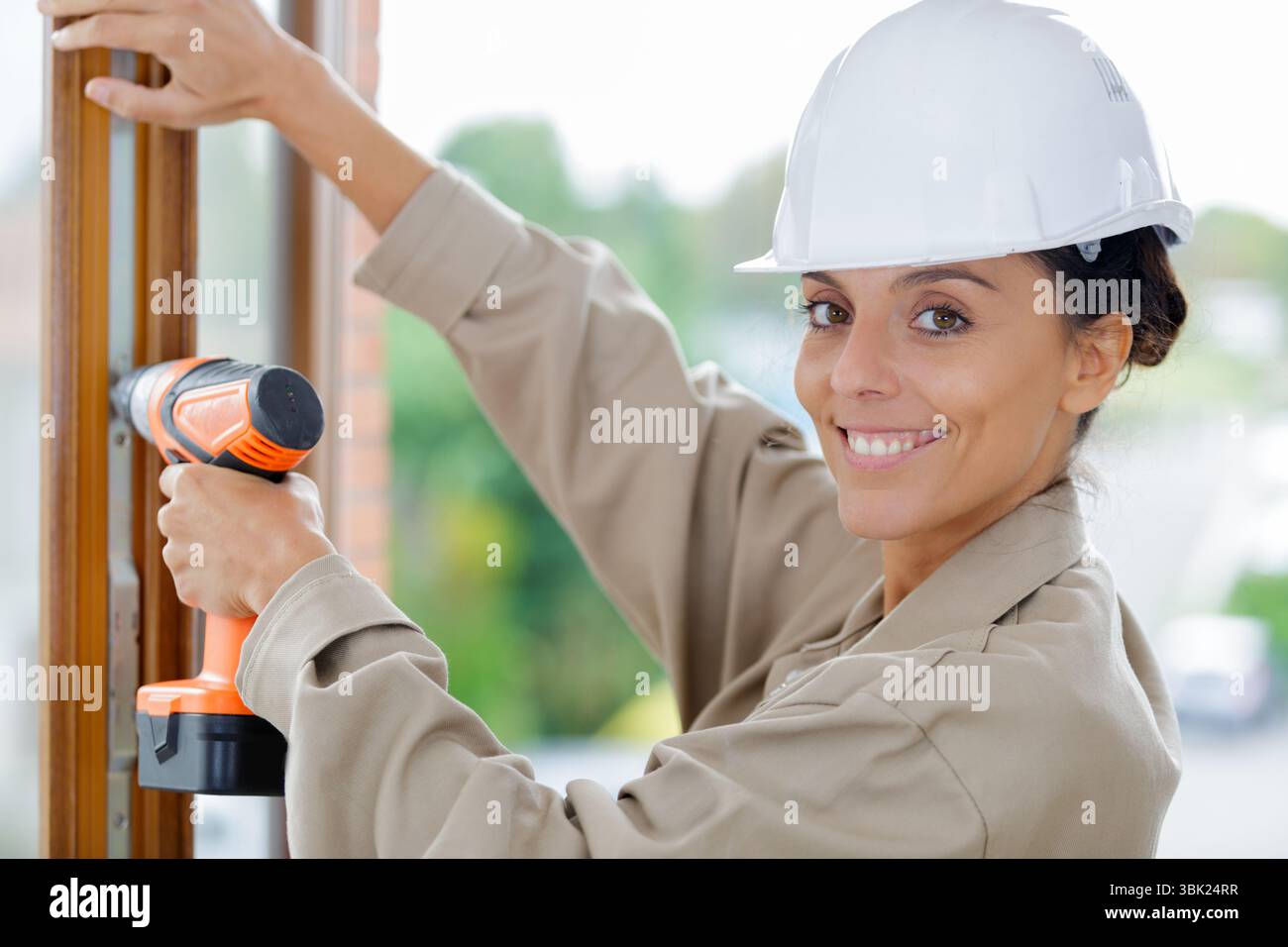 construction worker using cordless screwdriver on window Stock Photo