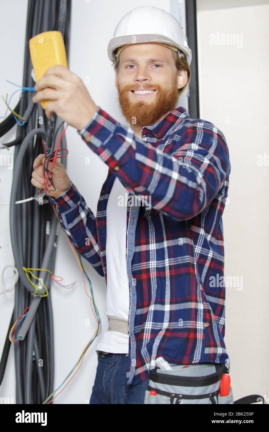 electrician testing wiring installation with multimeter Stock Photo