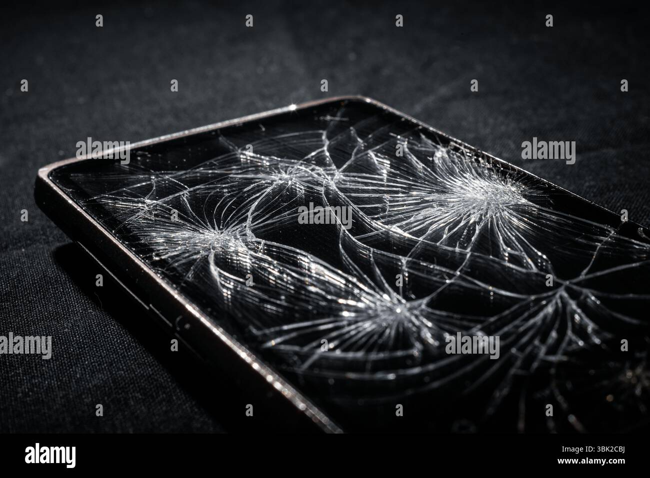 Smartphone with broken screen on dark background Stock Photo