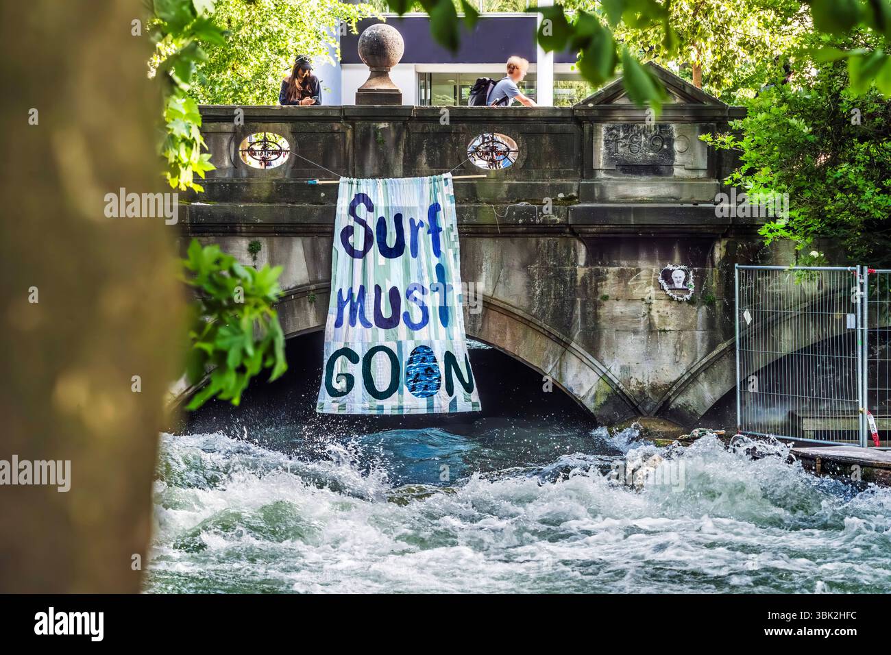 Gesperrte Münchner Eisbachwelle, Surfer fordern Freigabe, Surf must go on, Transparent an der Unfallstelle, München, Juni 2025 Deutschland, München, Juni 2025, Surf must go on, Transparent an der Unfallstelle, Münchner Eisbachwelle nach tödlichem Unfall einer Surferin im April weiterhin gesperrt, Münchner an der Unfallstelle, Surfer fordern die Eisbachwelle wieder freizugeben, das Surfverbot aufzuheben, River Surfing am Rand des Englischen Gartens, Bayern, bayerisch, *** Closed Munich Eisbach wave, surfers demand release, Surf must go on, banner at the accident site, Munich, June 2025 Germany, Stock Photo