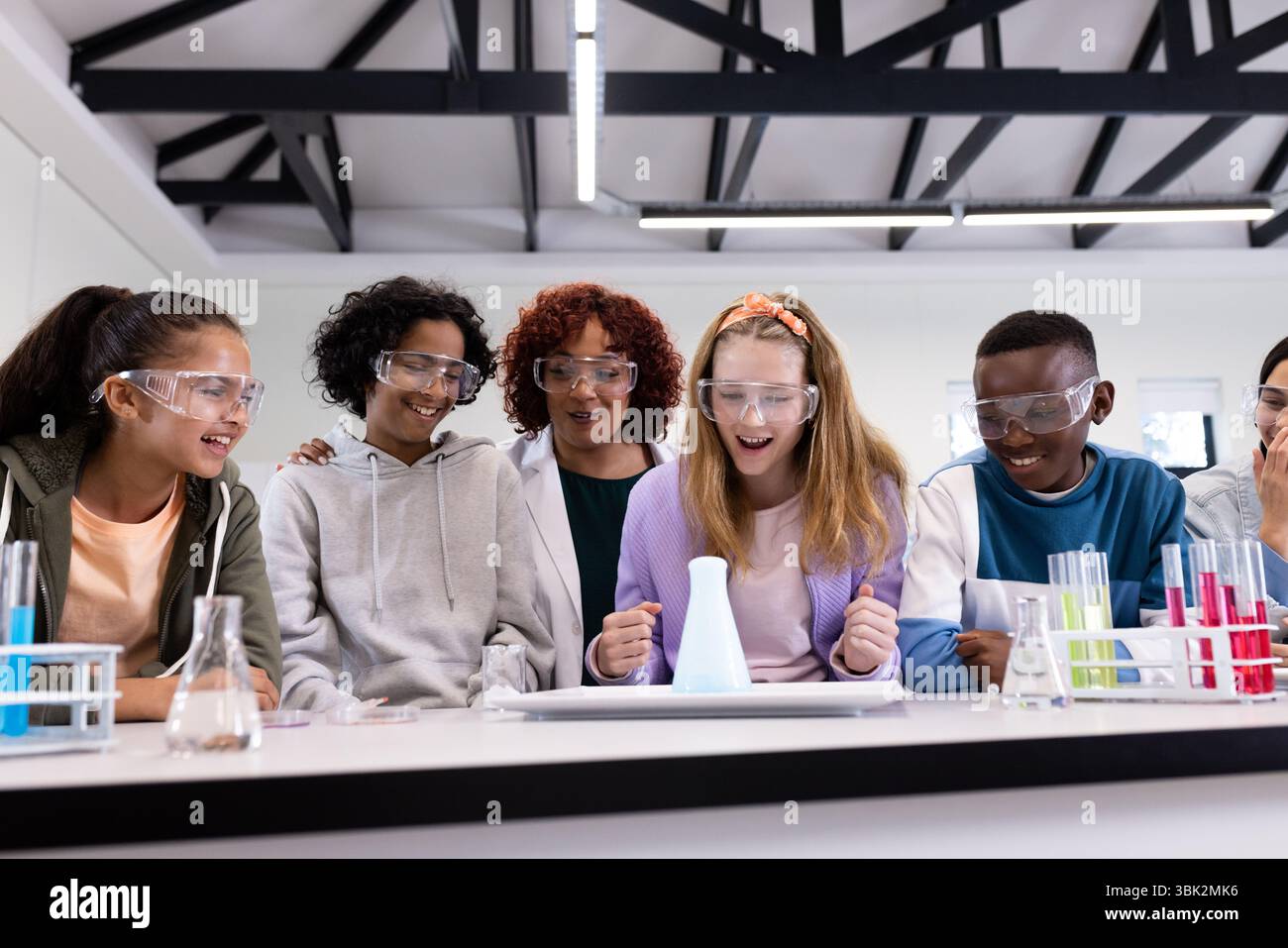 In school, diverse students conducting science experiment with female ...