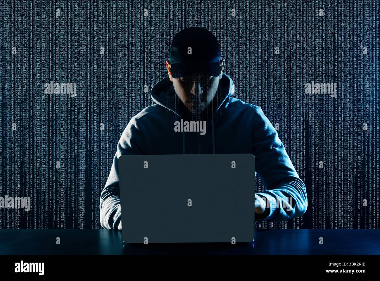 Cyber attack. Hacker working on laptop at table. Digital code behind him Stock Photo