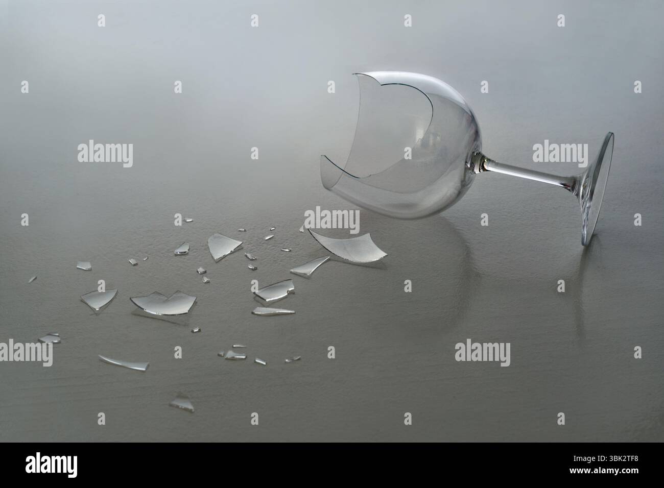 Broken wine glass with shattered fragments Stock Photo