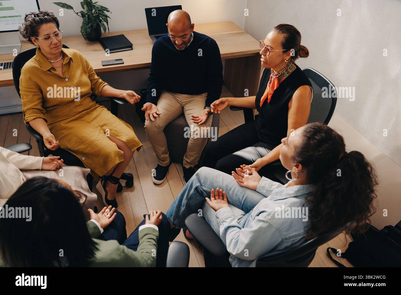 A group of professionals engaging in mindfulness techniques in an ...