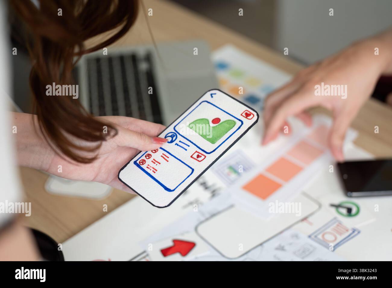 Mobile App Design. User interface mockup displayed on smartphone during collaborative session. Stock Photo