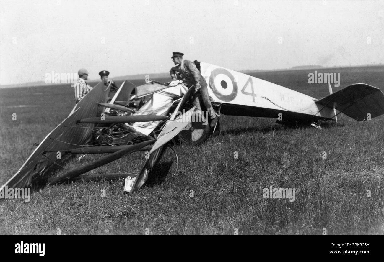 Wiltshire. 1925 – Wreckage of a Royal Air Force Avro 504K training bi-plane, registration H9814, of No.1 Flying Training School (1FTS), based at Netheravon. On 14 July 1925, this aircraft stalled while practising a gliding turn at low altitude, causing it to crash in a field at Charlton, Wiltshire. The pilot was killed instantly. The photograph shows RAF mechanics working on the aircraft before its removal. Another man, wearing a boating blazer and cap, is talking to one of the servicemen. Stock Photo