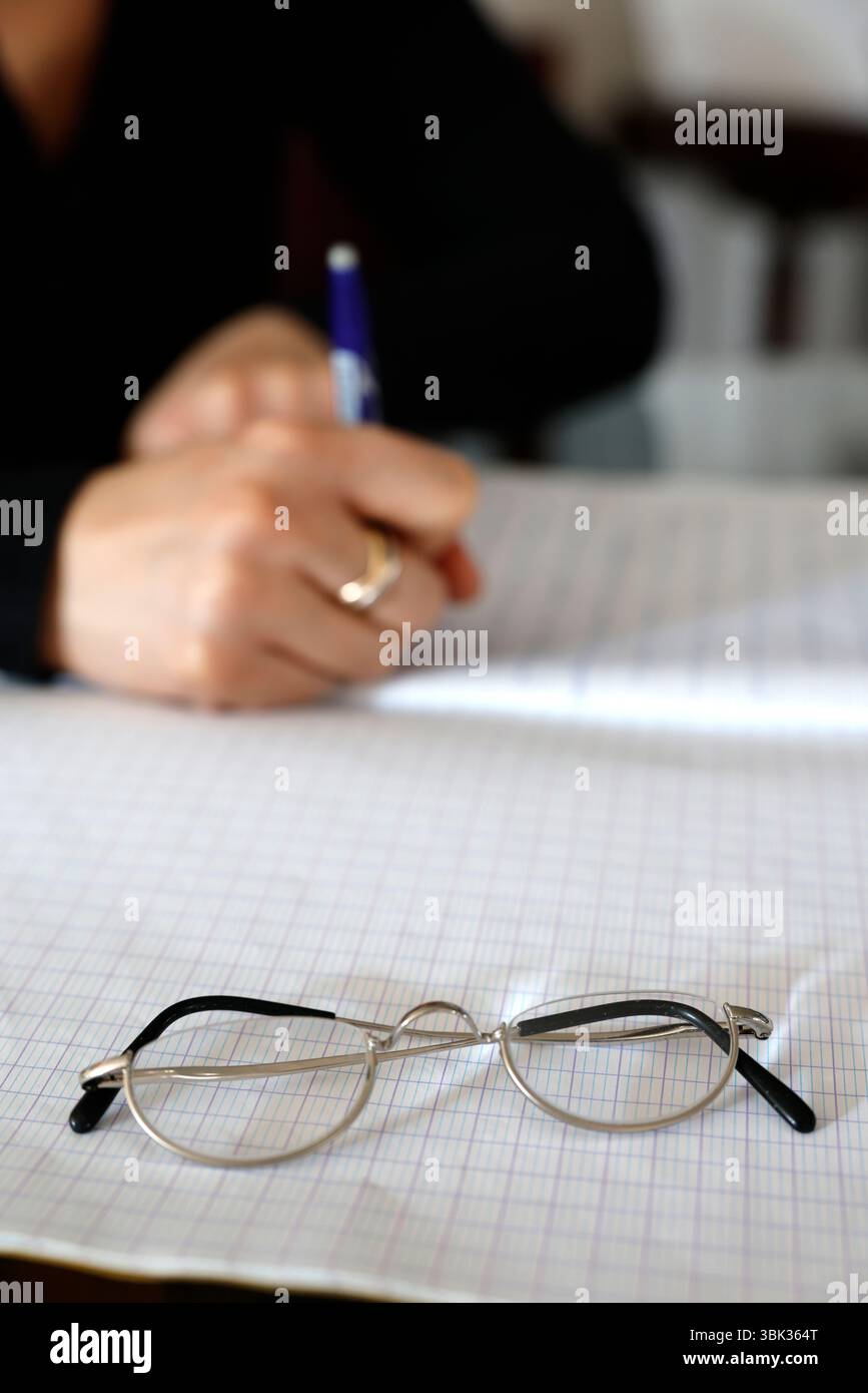 Young woman writing in a notebook. Homework. Stock Photo