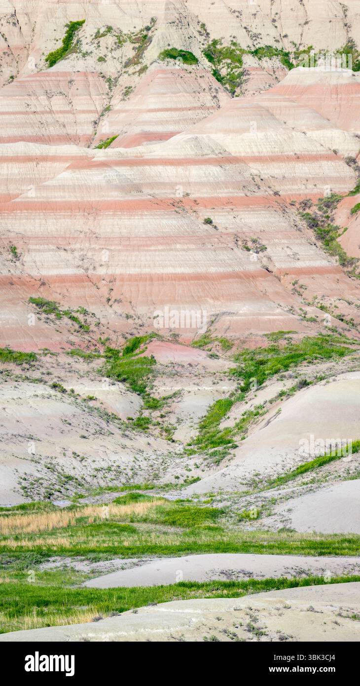 Rock formations with colorful pattern and grass at Badlands national park, South Dakota, USA. Stock Photo