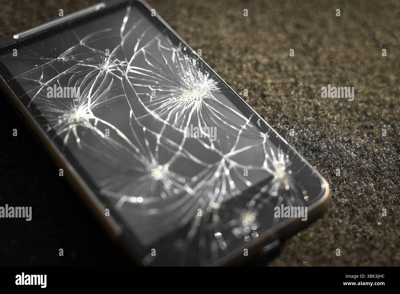Smartphone with broken screen on dark background Stock Photo