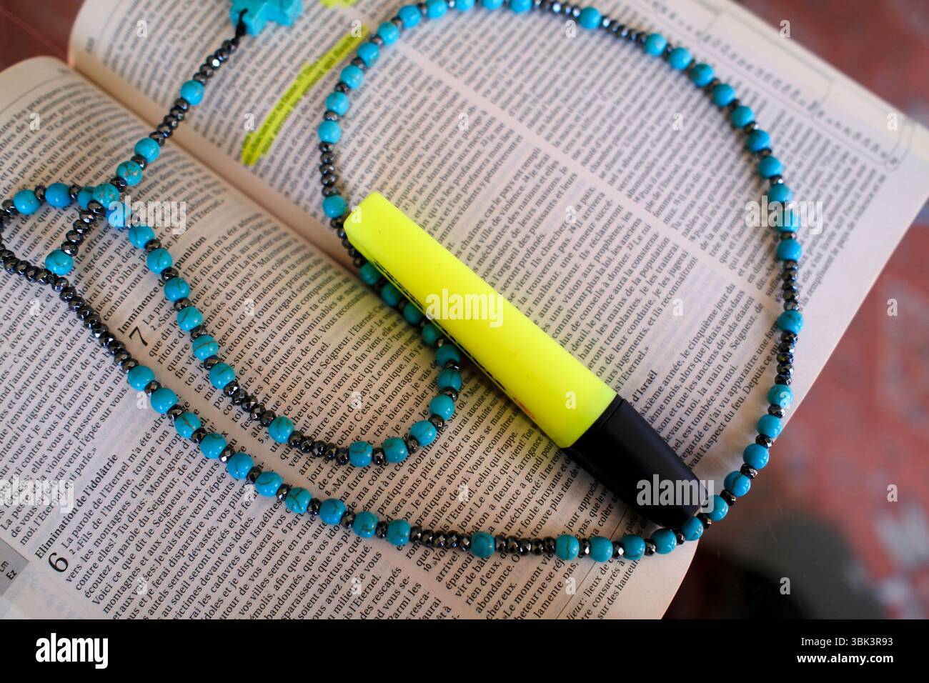 Bible with a blue rosary and a yellow highlighter. Stock Photo