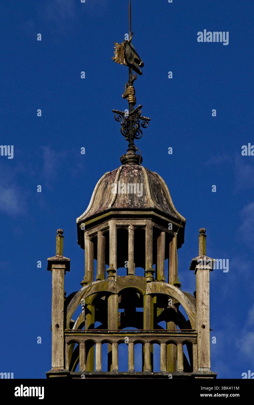 Golden hands grasp metal shaft of simple weather vane rising from ...