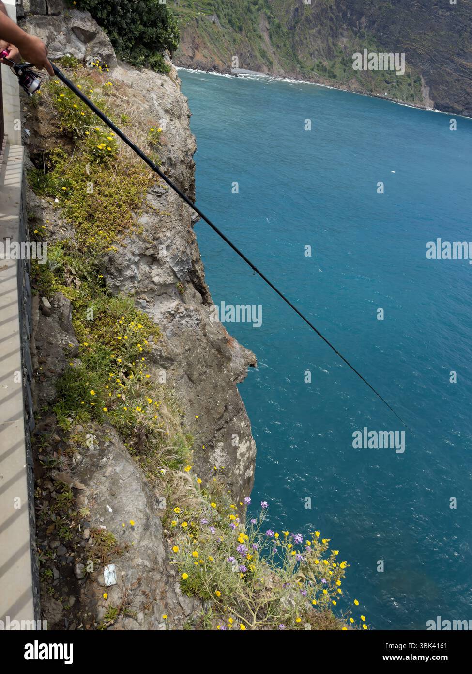 Fishing from rocky coast of Madeira, Portugal. Seascape coastline with small waves. - Smartphone Captured Stock Image