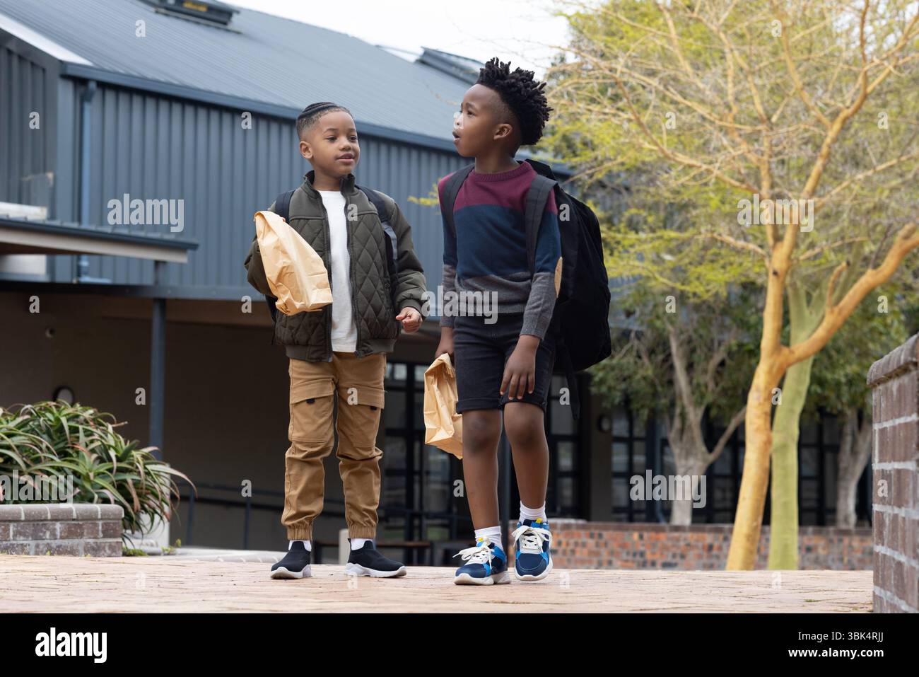 Boys walking with school bags hi-res stock photography and images - Alamy