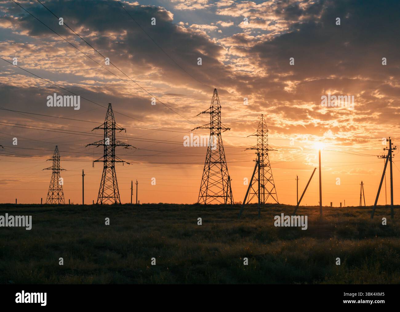 Sunset sky with power lines stretching over a desert landscape Stock ...