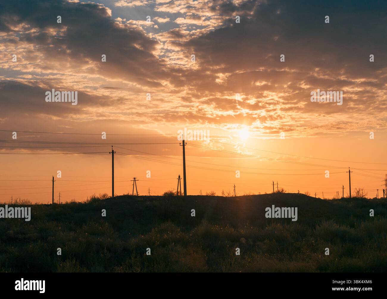 Sunset sky with power lines stretching over a desert landscape Stock ...