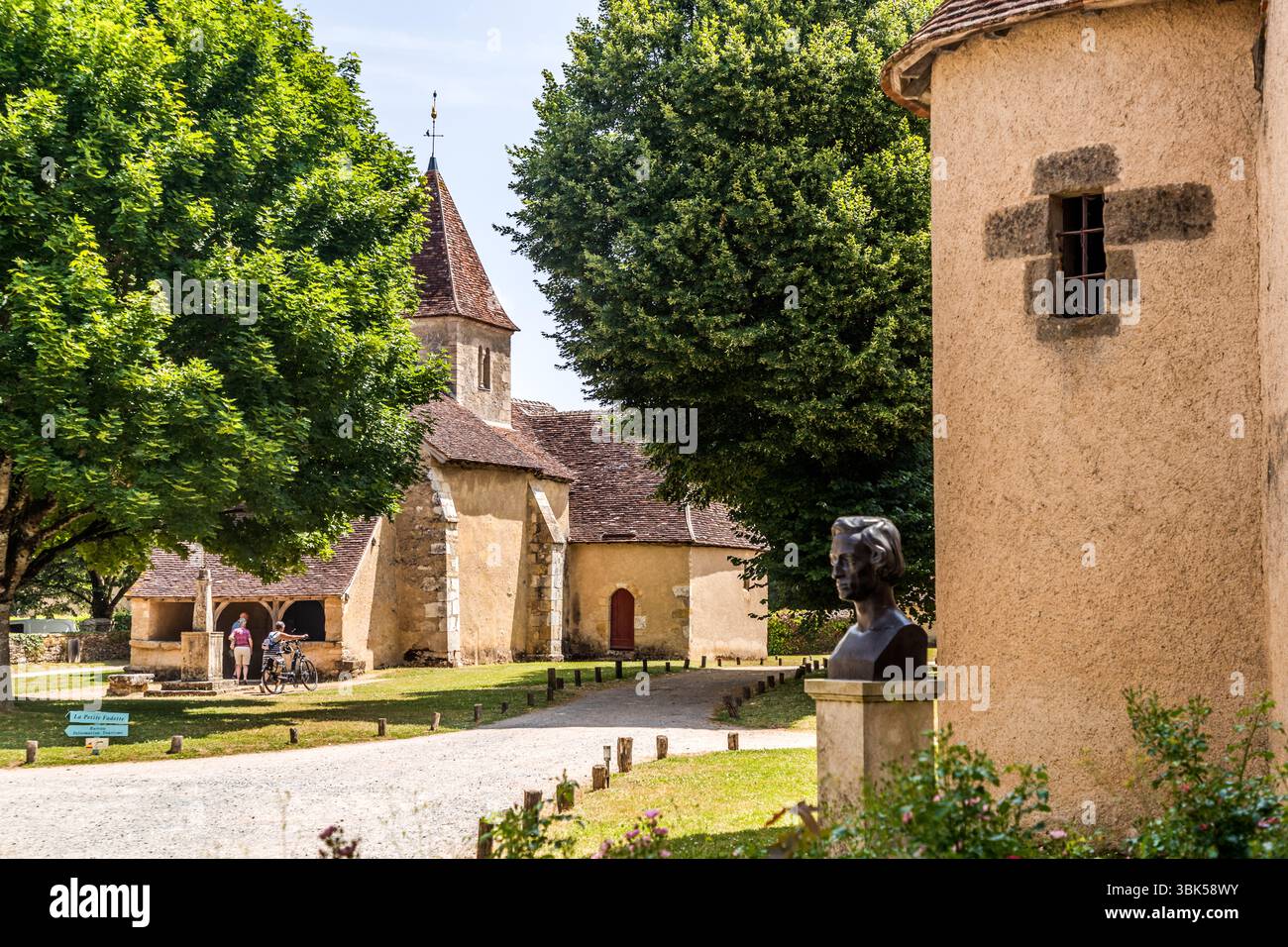 Statue of Frederique Chopin in front of the entrance to the Nohant estate, residence of George Sand. In the background, the small church of Nohant. The musician and composer was in a relationship with George Sand for nine years and spent a lot of time at Nohant. Some of his most important works were composed here from 1839 onwards. Place Sainte Anne, Nohant-Vic, Centre-Val de Loire, France Stock Photo