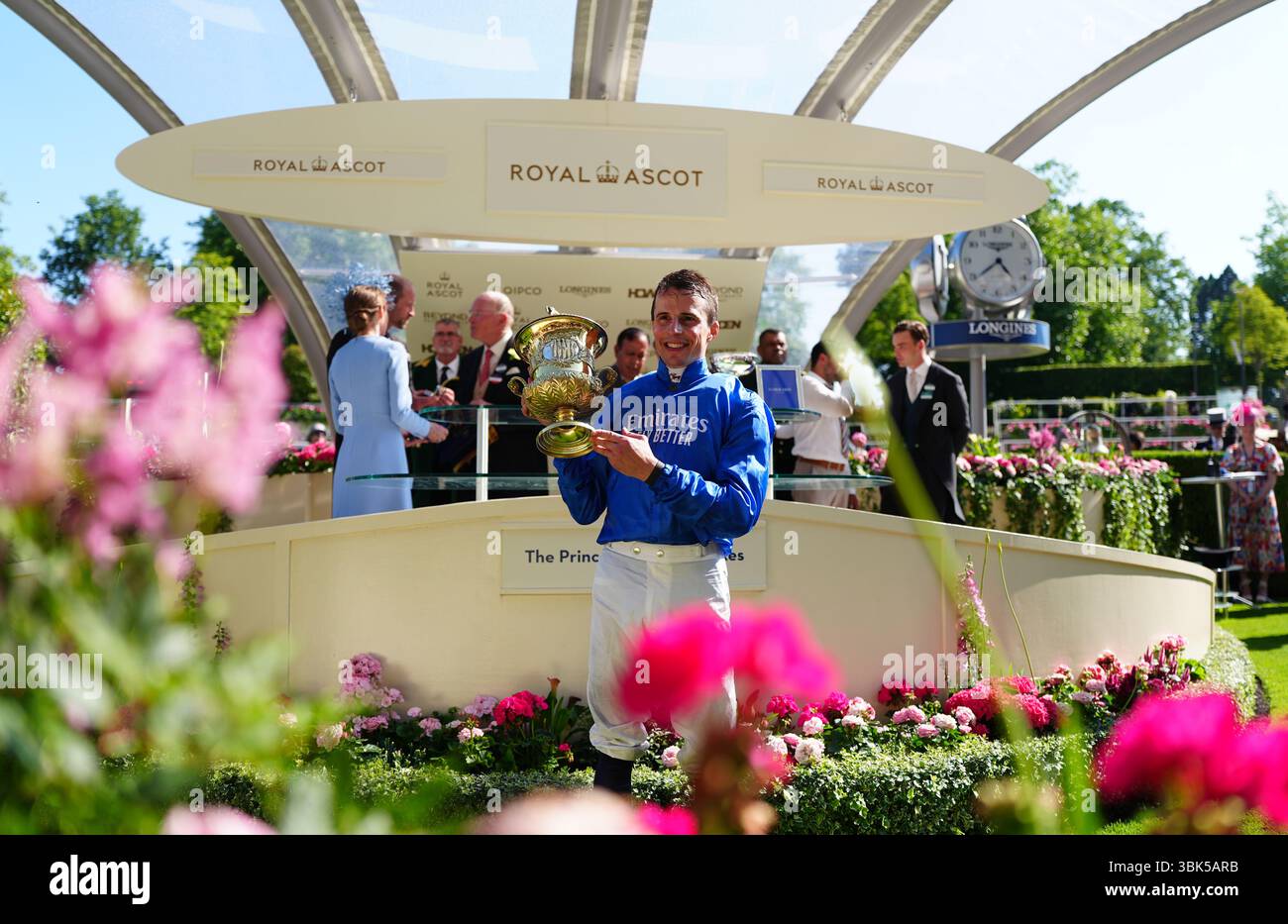 Jockey William Buick poses with the trophy after winning the Prince Of