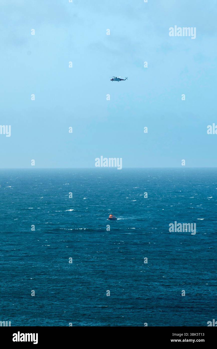 Shetland, Scotland, 18th June 2025 – Emergency response off Shetland coast – The Sumburgh coastguard rescue helicopter and Lerwick lifeboat respond to reports of a small skiff possibly sinking off the west coast of Shetland near St Ninian’s Isle. Shetland coastguard teams are assisting in the ongoing search operation. Credit: Dave Donaldson/Alamy Live News Stock Photo