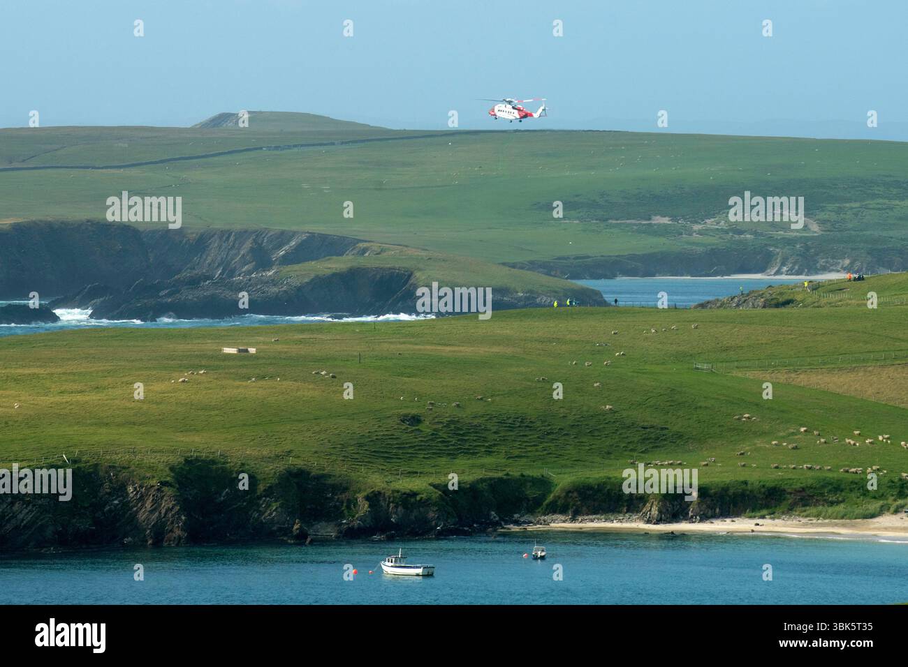 Shetland, Scotland, 18th June 2025 – Emergency response off Shetland coast – The Sumburgh coastguard rescue helicopter and Lerwick lifeboat respond to reports of a small skiff possibly sinking off the west coast of Shetland near St Ninian’s Isle. Shetland coastguard teams are assisting in the ongoing search operation. Credit: Dave Donaldson/Alamy Live News Stock Photo