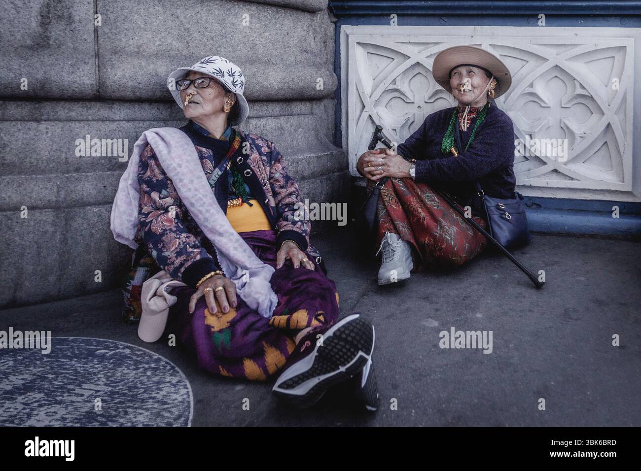 A candid image of two elderly Burmese women relaxing on Tower Bridge. Stock Photo